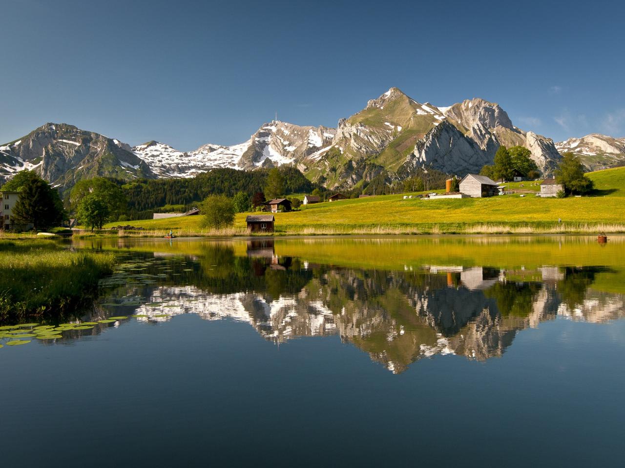 обои Небольшое озеро на деревне в горах фото