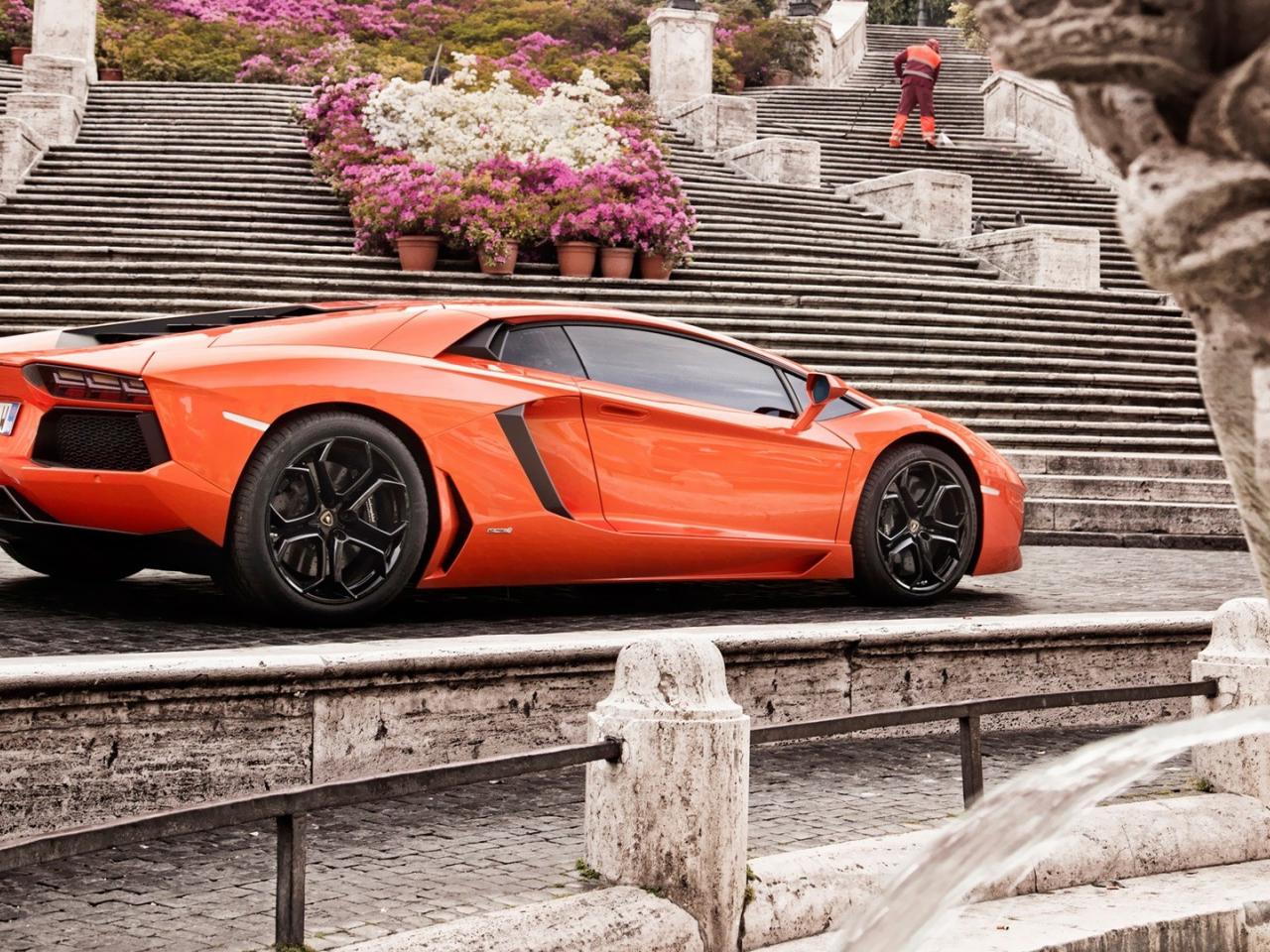 обои Оранжевый Lamborghini у каменной лестницы с цветами фото