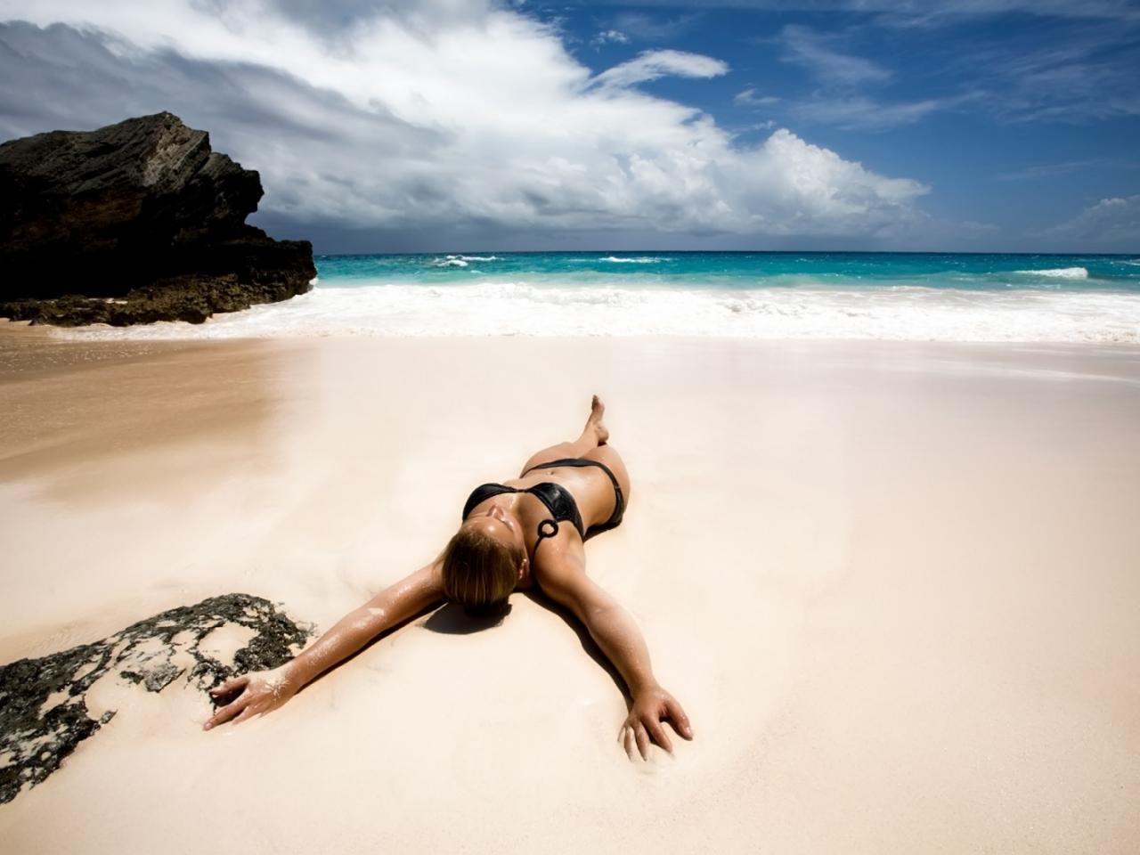 обои Девушка лежит на пляже на мокром песке фото