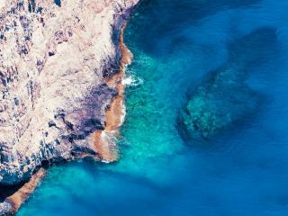 обои Голубая вода моря у скалы фото