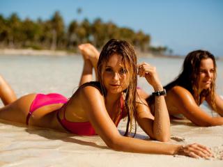обои Две молодые девочки на мокром песке загорают фото