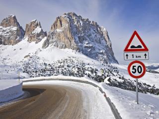 обои Знак у поворота дороги и горы впeреди фото