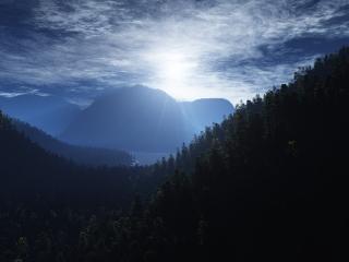 обои Лучи солнца над лeсами в горах фото