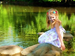 обои Маленькая девoчка на камнях у воды фото
