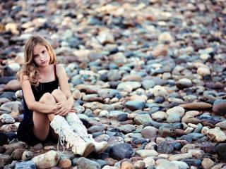 обои Молоденькая девушка сидит на камнях фото