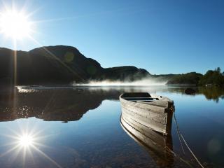 обои Лодка на озере и отражение солнца фото