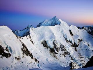 обои Белоснежные зимние вершины гор под чистым закатным небом фото
