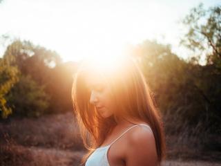 обои Лучи солнца над головой девушки фото