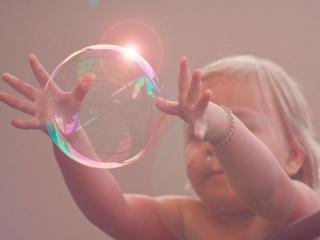 обои Ребёнок и огромный мыльный пузырь фото