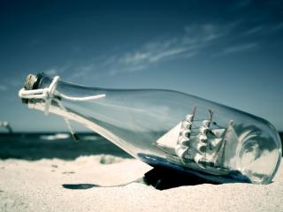 обои Кораблик, заточённый в бутылку, лежит на берегу моря фото