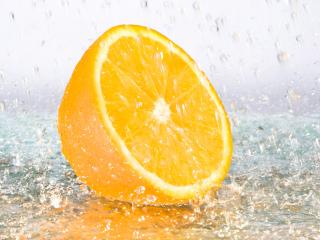 обои Свежая, сочная долька апельсина в брызгах воды фото