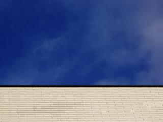 обои Чистое небо над серым зданием фото