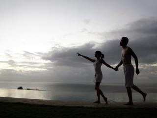 обои Влюблённая парочка, гуляющая по берегу вечером фото