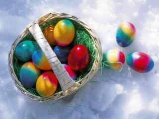 обои Корзинка с радужно раскрашенными яйцами на снегу фото