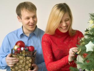 обои Парень с девушкой которые радостно наряжают новогоднюю елку фото