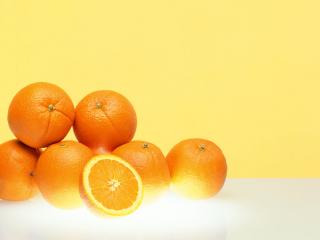 обои Сочные оранжевые апельсины на желтом фоне фото