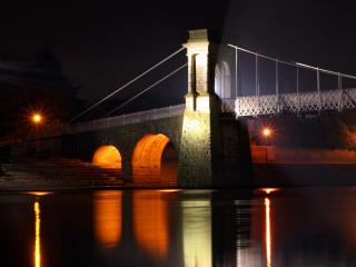 обои Освещенный фонарями массивный мост ночью фото