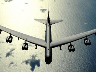 обои Военный самолет над океаном в облаках фото