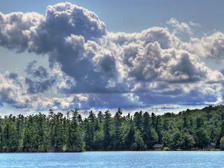 обои Пушистые облака над озером и лесом фото