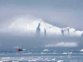 обои Рыбацкая лодка у края большого айсберга фото