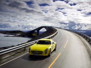 обои Желтая машина на дороге под облаками фото