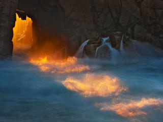 обои Освещенный тоннель из скалы с водопадами фото