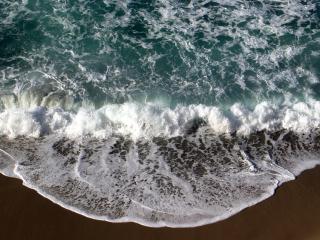 обои Пенистая волна накатывает на морской песок фото
