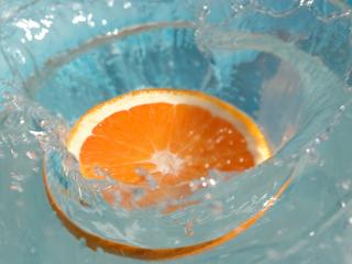 обои Долька апельсина в стакане с водой фото