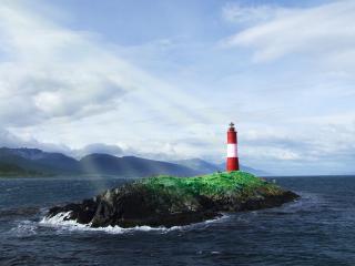 обои Одинокий маяк на маленьком островке каменистом фото