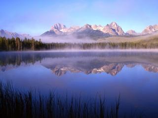 обои Туманное озеро с тихой водой у подножия гор фото