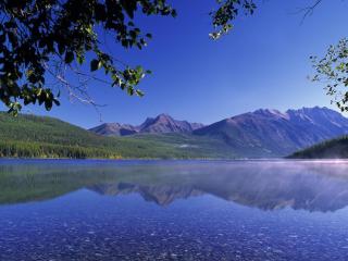 обои Неглубокое и прозрачное озеро и горы с лесами вдали фото