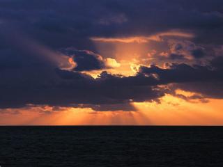 обои Багряное солнце заходящее в свинцовых облаках фото
