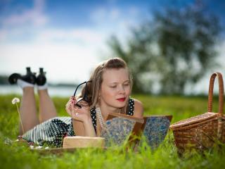 обои Девушка с лукошком читает книгу на траве фото