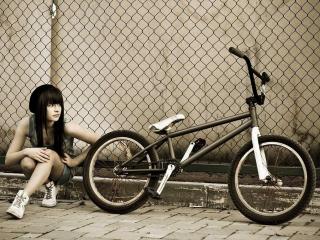 обои Девчока с велосипедом сидит на тротуаре фото